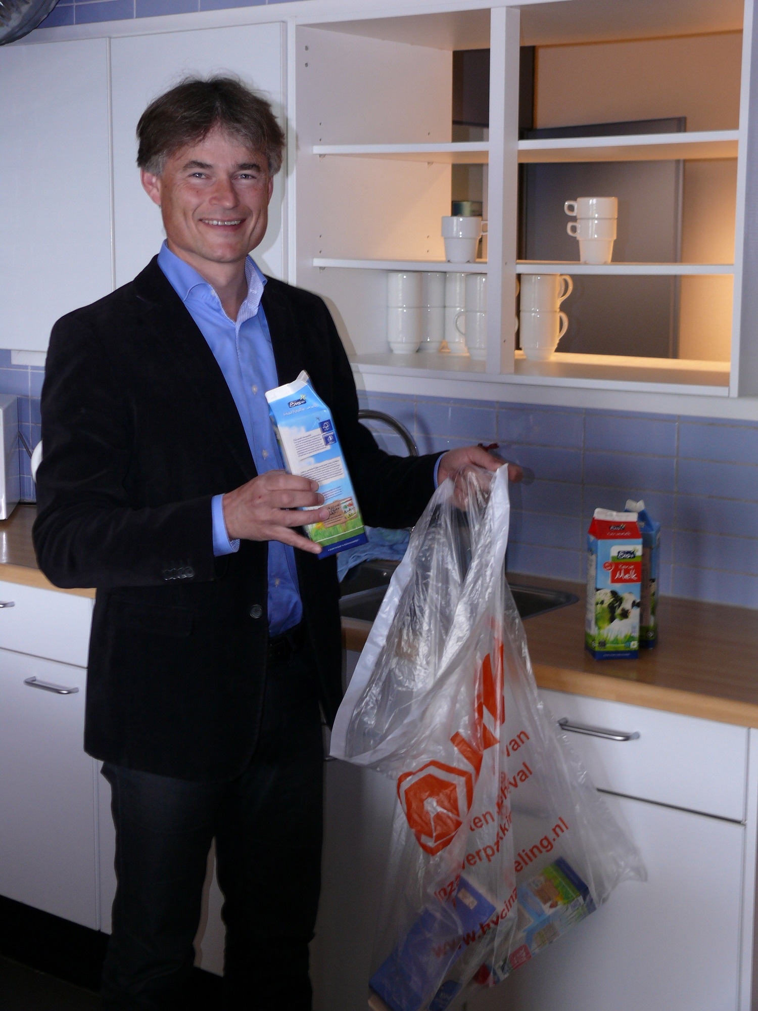 Wethouder Sigge van der Veek gooit ook zijn melkpakken in de zak voor plastic verpakkingsafval.